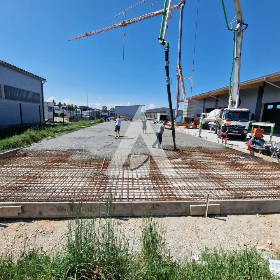 Bewehrte Bodenplatte mit Betonpumpe kurz vor der Betonage