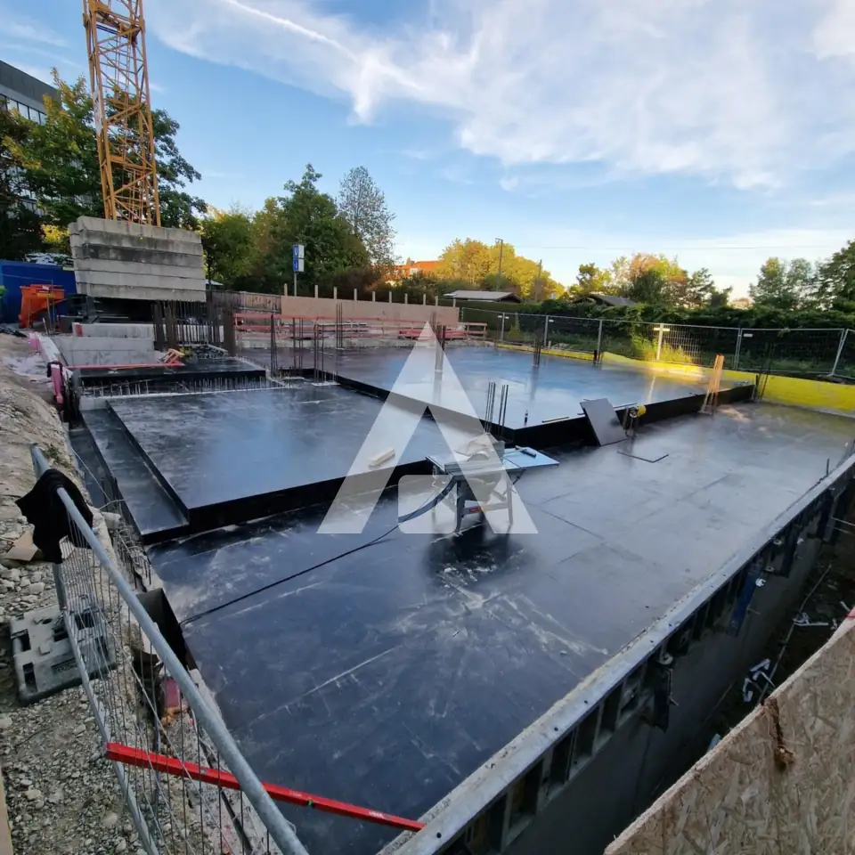 Bodenplatte mit Abdichtung und Turmdrehkran auf der Baustelle