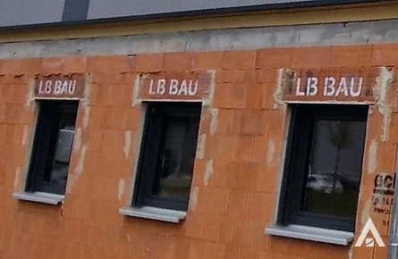 Rollladenkästen mit LB-Bau-Aufdruck im Ziegelmauerwerk