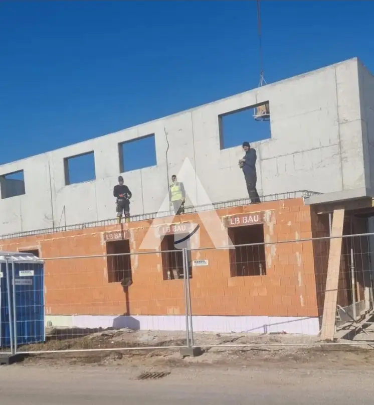 Team der LB Bau GmbH auf dem Rohbau, Rollladenkästen mit LB-Bau-Aufdruck
